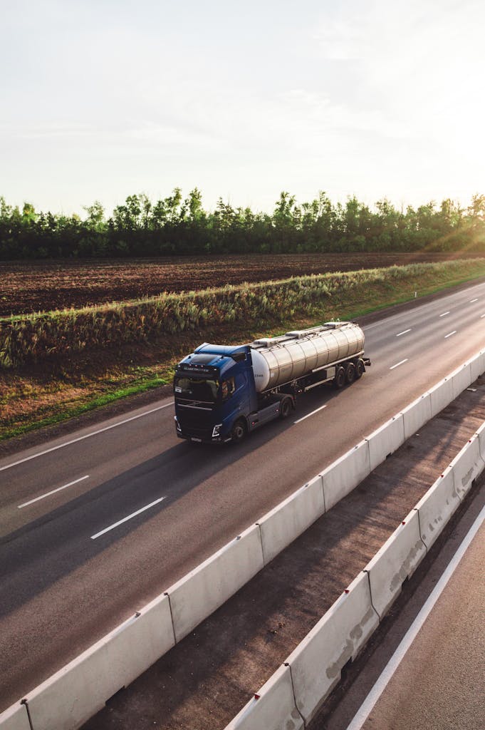 A tanker truck traveling on a highway in Russia during sunset, capturing the essence of transportation.