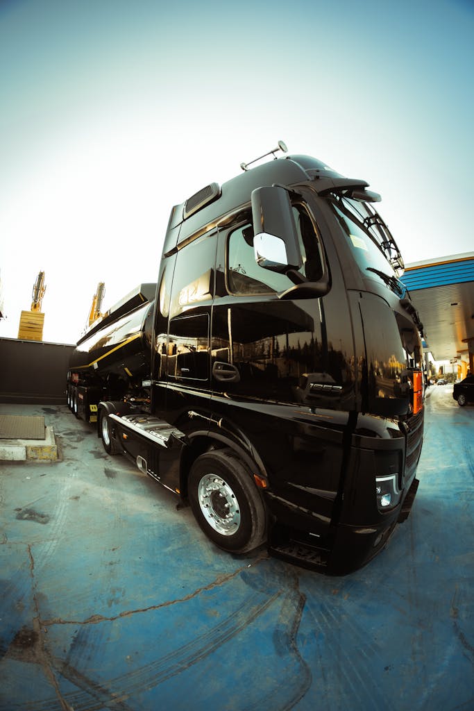 High-angle shot of a sleek black truck parked in an open area under bright sunlight.